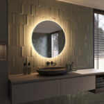 De verlichting schijnt zowel naar voren voor praktisch licht in het gezicht als vanachter de spiegel fraai en sfeervol over de wand en zorgt daarmee voor veel omgevingslicht