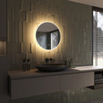 De verlichting schijnt zowel naar voren voor praktisch licht in het gezicht als vanachter de spiegel fraai en sfeervol over de wand en zorgt daarmee voor veel omgevingslicht