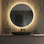Ronde design spiegel met een diameter van 100 cm en van alle gemakken voorzien: dimbare verlichting, spiegelverwarming en instelbare lichtkleur