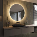 De verlichting schijnt zowel naar voren voor praktisch licht in het gezicht als vanachter de spiegel fraai en sfeervol over de wand en zorgt daarmee voor veel omgevingslicht