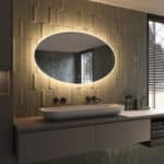 De verlichting schijnt zowel naar voren voor praktisch licht in het gezicht als vanachter de spiegel fraai en sfeervol over de wand en zorgt daarmee voor veel omgevingslicht