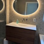 Klant foto: ovale badkamer spiegel met verlichting op grijze tegelwand