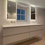 Dubbele smalle badkamer spiegel op marmeren wand