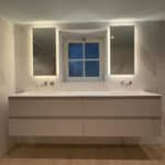 Dubbele smalle badkamer spiegel op marmeren wand