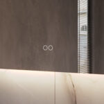 Uitgevoerd met een dubbele touch schakelaar in het spiegelglas; linker touch knop voor het gelijktijdig in- en uitschakelen van de verlichting en de verwarming, inclusief geïntegreerde dimfunctie voor de verlichting, rechter touch knop om traploos de gewenste kleur van de verlichting in te stellen