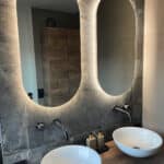 2 verticale ovale badkamer spiegels op een grijs marmeren wand