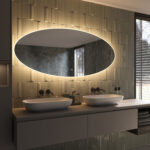 De verlichting schijnt zowel naar voren voor praktisch licht in het gezicht als vanachter de spiegel fraai en sfeervol over de wand en zorgt daarmee voor veel omgevingslicht