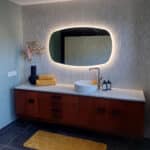 Deens ovale spiegel op wand met witte verticale tegels