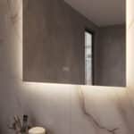 Uitgevoerd met een dubbele touch schakelaar in het spiegelglas; linker touch knop voor het gelijktijdig in- en uitschakelen van de verlichting en de verwarming, inclusief geïntegreerde dimfunctie voor de verlichting, rechter touch knop om traploos de gewenste kleur van de verlichting in te stellen