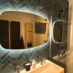 Deens ovale spiegel op visgraat tegelwand