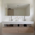 Badkamer spiegel met stopcontact op wit gestucte wand